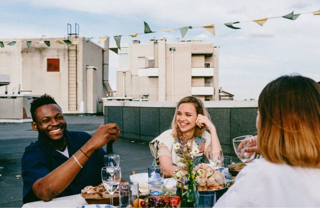 Gruppe von Freunden am Abendessen auf einem Großstadtdach